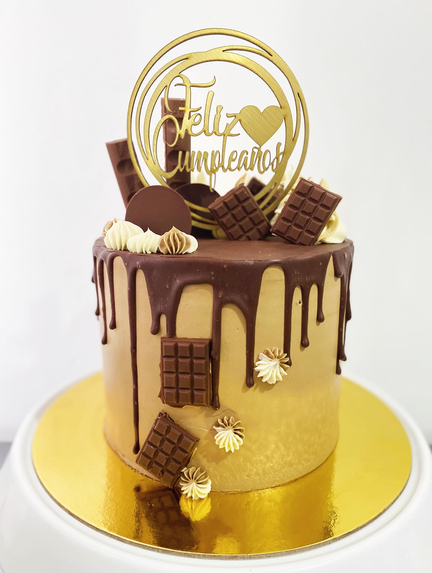 Drip cake de chocolate con barras de chocolate y topper Feliz Cumpleaños