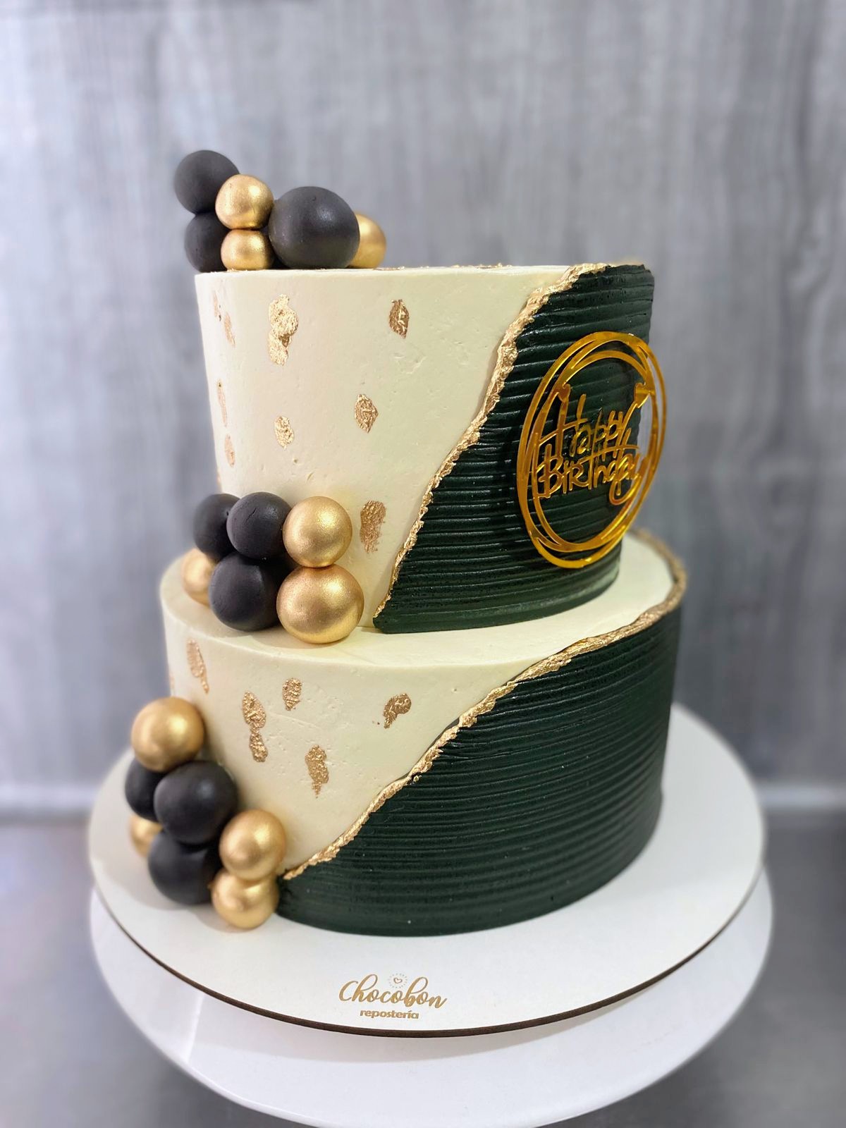 Torta elegante de dos pisos en verde botella, marfil y pan de oro