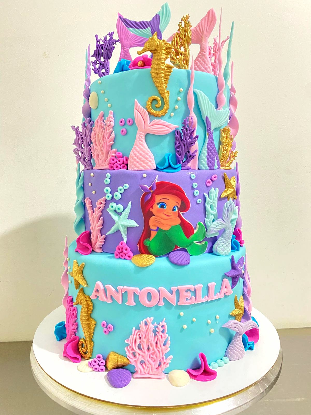 Torta infantil de tres pisos con temática submarina, corales y sirenas