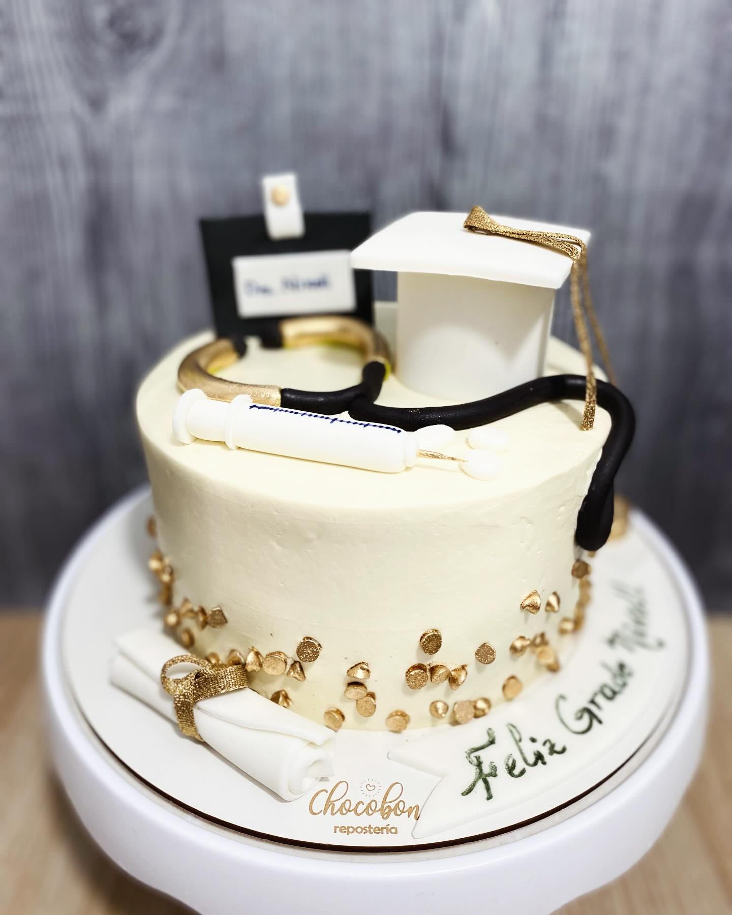 Torta de grado de medicina con estetoscopio, jeringa, diploma y birrete modelados a mano